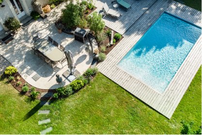 Vue de haut d'un jardin avec une terrasse en bois et une piscine