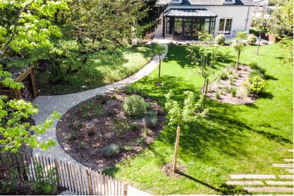 Vue d'un jardin avec des allées et des bosquets aménagés