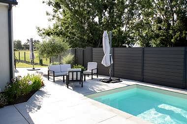 Vue de haut d'un jardin avec une terrasse en bois et une piscine